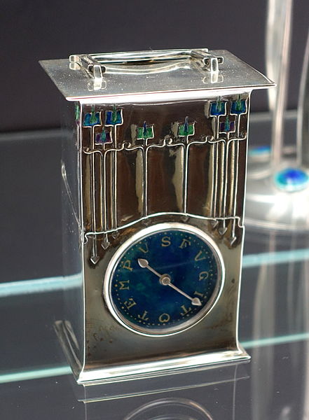 File:Table clock 'The Magnus', designed by Archibald Knox, made by W. H. Haseler, Birmingham, for Liberty & Co., London, 1902, silver, enamel - Bröhan Museum, Berlin - DSC03941.JPG