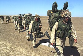 A Marine with the 15th Marine Expeditionary Unit leads a column to a security position after seizing a Taliban forward-operating base in November 2001. U.S. Marines humping in Afghanistan, November 2001.jpg