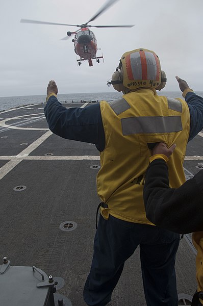 File:U.S. Navy Boatswain's Mate 2nd Class Nolan McSwain, assigned to the guided missile frigate USS Ford (FFG 54), directs the pilots of a Coast Guard MH-65 Dolphin helicopter on the ship's flight deck 130508-N-ZF573-264.jpg
