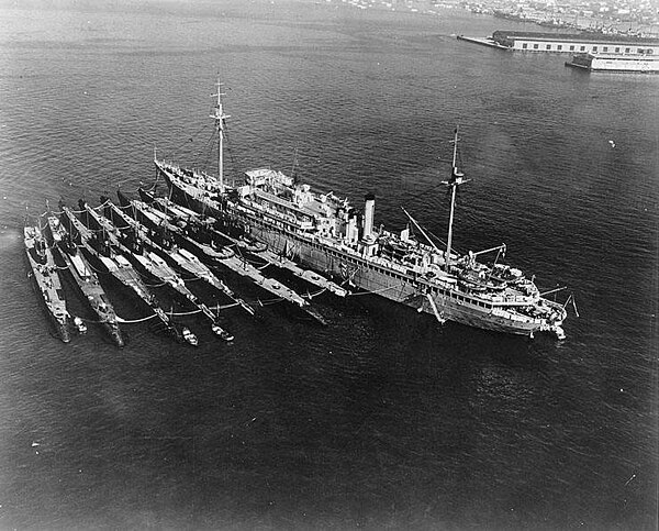 V-boats (left to right): Cachalot, Dolphin, Barracuda, Bass, Bonita, Nautilus, Narwhal, with submarine tender Holland.