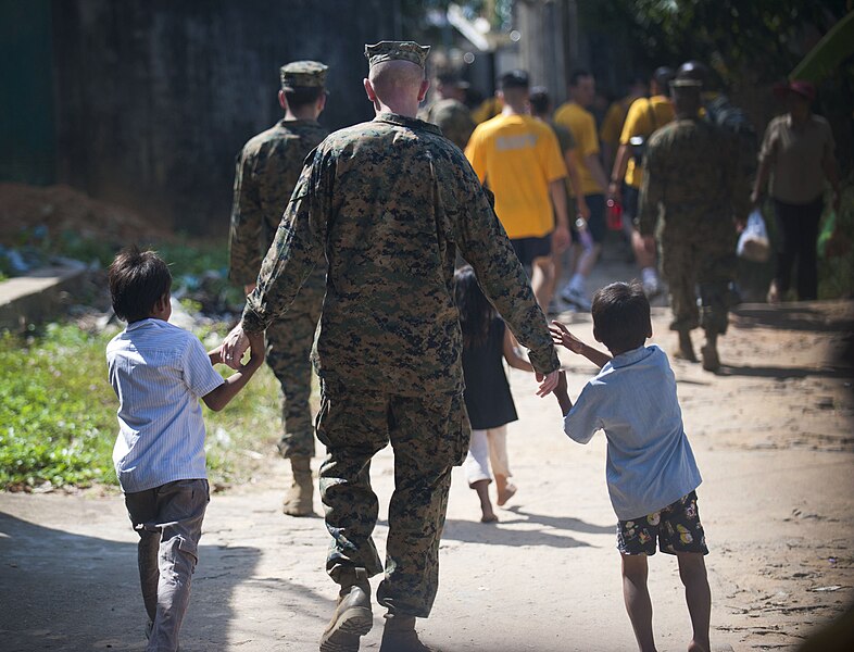 File:US Navy 111215-N-PB383-615 A Marine assigned to the 11th Marine Expeditionary Unit (11th MEU) walks with children during a community service event.jpg