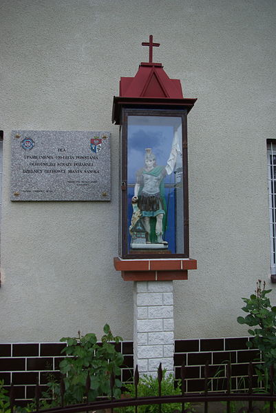 File:Voluntary Fire Brigade in Sanok-Olchowce, statue of Saint Florian and plaque.jpg