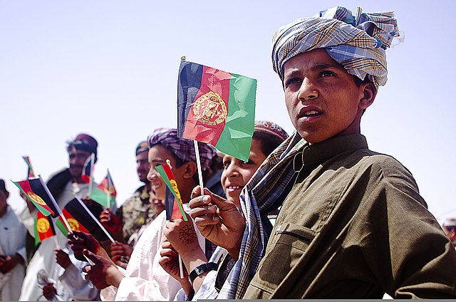 Afghan children waving national flags in Helmand Province