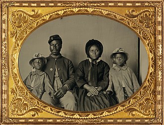 Union soldier in uniform with family-recently Identified as Sgt Samuel Smith of the 119th USCT and family African American soldier in Union uniform with wife and two daughters (cropped).jpg