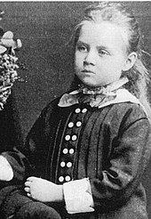 Portrait d'une petite fille aux cheveux clairs d'environ cinq ans.