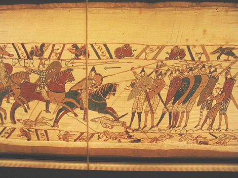 Norman cavalry armed with lances attacks the Anglo-Saxon shield wall. Notice the dominance of the spearmen in the front line of the formation. In the back of the formation there is one warrior armed with a battle-axe, one archer, and one javelineer. There are javelins in mid-flight and slain soldiers pierced with javelins on the ground Bayeux Tapestry 4.jpg