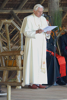 Pope Benedict XVI in white cassock (sometimes though unofficially called a simar) with pellegrina and fringed white fascia BentoXVI-58-12052007.jpg