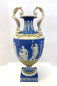 Tünd göy rəngli yəşəmi qab. Con Flaksmenin dizaynı əsasında "Wedgwood" manufakturası tərəfindən 1785-ci ildə istehsal edilmiş "Herakl hesperidlərin bağında" adlı güldan. Urbana-Şampeyn İllinoys Universitetinin Krannert Sənət Muzeyi, Şampeyn, İllinoys, ABŞ