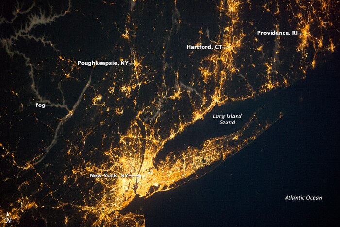 Nocturnal view of the New York City metropolitan area, the world's most brightly illuminated[citation needed] conurbation and largest urban landmass. Long Island extends 120 miles eastward from Manhattan, the central core of the conurbation.