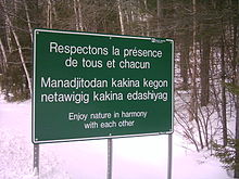 Sign at La Vérendrye Wildlife Reserve in French, Algonquin and English. The Algonquin text Manàdjitòdan kakina kegòn netàwigig kakina e-dashiyag literally translates to Be gentle with all things of nature for everyone.