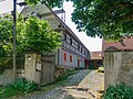 Wohnstallhaus und Scheune sowie gepflasterte Heiste, Hofbaum (Kastanie) und Toreinfahrt eines Bauernhofes