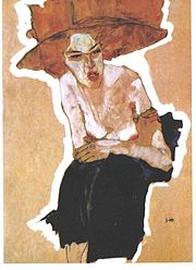 Portrait d'une femme en chapeau assise de face, mine grimaçante et bras croisés
