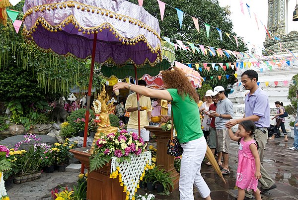 People performing water pouring on Buddha statues during Songkran in Wat Pho, Bangkok