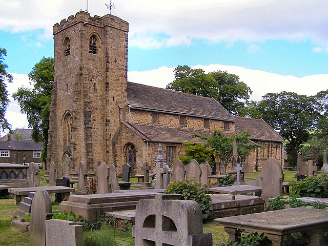 A stone church seen from the southeast with an embattled tower, clerestory, and a lower chancel.