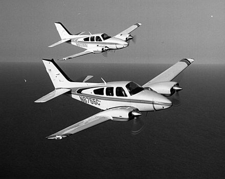 Two Baron 55s flying in formation with a 1980-built B55 nearest. E55 in background.