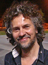 The close-up of a light-skinned man with curly gray hair.