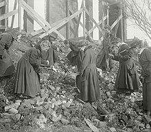Mignon Talbot (second from left) and students searching the rubble of the burned down Williston Hall in 1917 Williston Hall debris.jpg