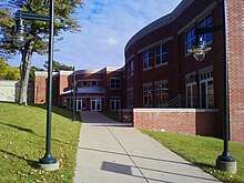 Picture of a campus building with a walkway on an autumn day