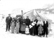 UMWA strikers at the Forbes Colony, 1914. After the 10 March destruction of the colony, Joseph Zanetell (light cap, in front of chimney) would lose two newborn twins to exposure. Zanetell tent at Forbes tent colony.png