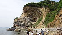 A wave-like sea cliff produced by coastal erosion, in Jinshitan Coastal National Geopark, Dalian, Liaoning Province, China Da Lian Guo Jia Di Zhi Gong Yuan 9-Hai Shi Ya .JPG