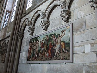 Les murs latéraux du déambulatoire sont garnis d'arcatures dotées de clés pendantes. Elles sont généralement ornées de têtes humaines. Le tableau représente la Lapidation de saint Étienne.