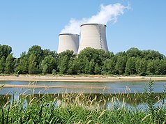 Kerncentrale in Cattenom, Frankrijk, vier grote koeltorens die witte waterdamp verdrijven tegen een blauwe lucht