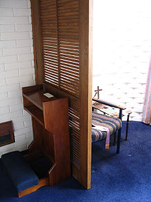 Modern confessional in the Church of the Holy Name, Dunedin, New Zealand. The penitent may kneel on the kneeler or sit in a chair facing the priest (not shown) Confessional Modern.jpg