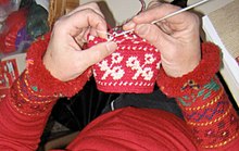 In Finland, yarns are placed to the front and back of the same finger to quickly change colors and the hook is inserted into the back loop. FinlandTapestryCrochet.jpg