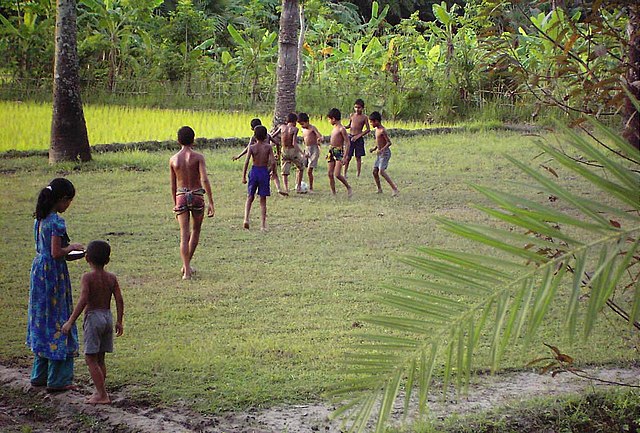 Rural children playing football in a Bangladeshi village