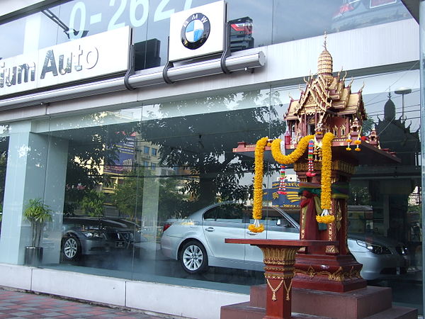 A Thai spirit house for the Chao Thi in front of a car dealership in Bangkok