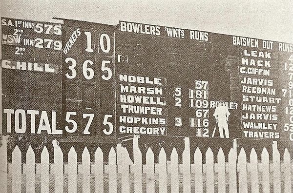 Hill standing in front of the Adelaide Oval scoreboard after scoring 365 against New South Wales in 1900–01