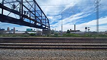 The truss bridge crossing above railroads largely remains intact even after a large portion of the Paulina Connector was demolished. Logan Square branch truss bridge.jpg