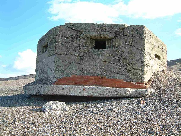 A British World War II type 22 hexagonal pillbox in Kelling on the North Norfolk coast, England. The pillbox broke up during winter storms in February