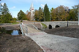 Gangbro ved siden af stenbroen over floden Vigala. 
 Rapla kirke i baggrunden.