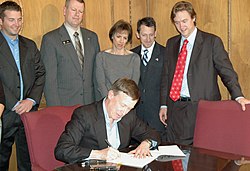 Johnston (right) watches as Governor John Hickenlooper signs HB-1262 in 2011 Sen. Brophy (5572790912).jpg