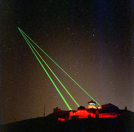 Three green lasers being fired at a single spot in the sky from the Starfire Optical Range