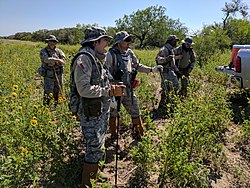 Texas State Guardsmen searching during a humanitarian mission. TXSG Operation Final Rest.jpg