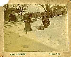 Two adolescent girls shoveling snow after a heavy snowfall