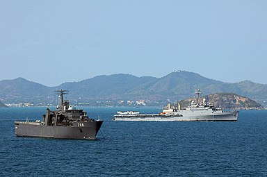 RSS Resolution at anchor in the Gulf of Thailand, with USS Denver passing behind during Cobra Gold '11.