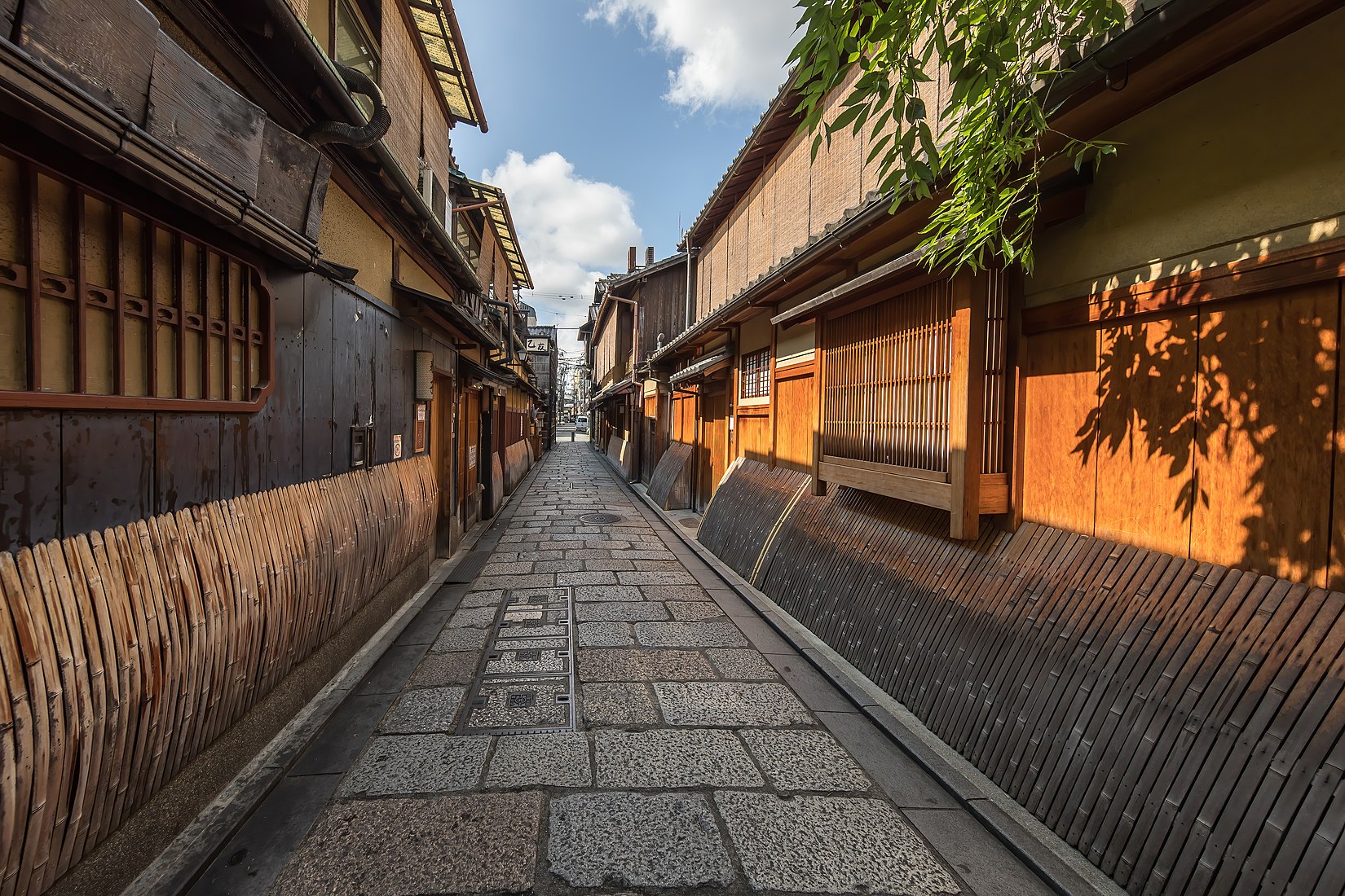 Wooden and bamboo facades of dwellings with sudare in a cobbled street of Gion, perspective effect with vanishing point, Kyoto, Japan.jpg