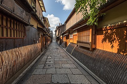 Wooden and bamboo facades of dwellings with sudare in a cobbled street of Gion, perspective effect with vanishing point, Kyoto, Japan