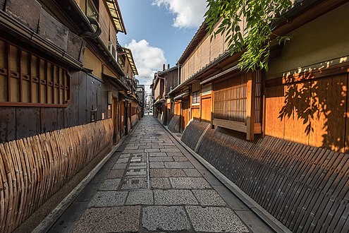 Дървени и бамбукови фасади на жилища със сударе в калдъръмена улица на Гион, перспективен ефект с точка на изчезване, Киото, Япония.jpg