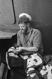 A submariner from HMS Taku making additions to the boat's Jolly Roger Adding Another Success Bar To Submarine Taku's Jolly Roger. February and March 1943, at HMS Talbot, Malta. A15093.jpg