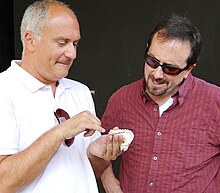 Georgian archaeologist and anthropologist David Lordkipanidze (left) showing a hominin jaw discovered at Dmanisi to American ambassador John R. Bass in 2010 Amb. Bass-with-D.Lordkipanidze at Dmanisi 2010.JPG