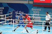 Deutsch: Boxen bei den Olympischen Jugendspielen 2018 Tag 12, 18. Oktober 2018 - Kampf um Bronze im Leichten Weltergewicht Jungen – Hassan Azim (Großbritannien, rot) schlägt Mohammed Boulaouja (Marokko, blau) RSC; Ringrichter ist Wulfren Olivares Peréz (Kolumbien). English: Boxing at the 2018 Summer Youth Olympics on 18 October 2018 – Bronze Medail Match Light Welterweight Boys - Hassan Azim (Great Britain, red) beats Mohammed Boulaouja (Morocco, blue) RSC; Referee is Wulfren Olivares Peréz (Columbia). Español: Boxeo en los Juegos Olímpicos Juveniles de Verano de 2018 en 18 de octubre de 2018 - Medalla de bronce de los hombres ligeros de peso welter: Hassan Azim (Gran Bretaña, rojo) vence a Mohammed Boulaouja (Marruecos, azul) RSC; El árbitro es Wulfren Olivares Peréz (Colombia).