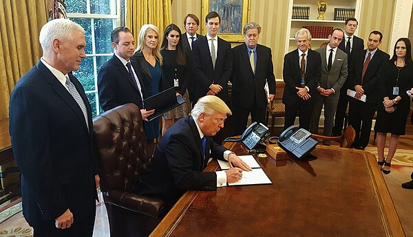 Bannon and other advisors watching Trump sign an executive order in the Oval Office in January 2017