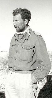 unkempt man in British Army uniform, with hands in pockets