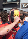 Belgisk fotbollssupporter som målat ansiktet som Belgiens flagga