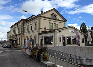 Wide three-story building with gabled roof