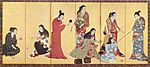 Seven women and a girl dressed in kimonos. Two women are playing cards, one is cleaning her teeth while holding a mirror, another is holding a twig, one is writing. Two women are engaged with the girl.